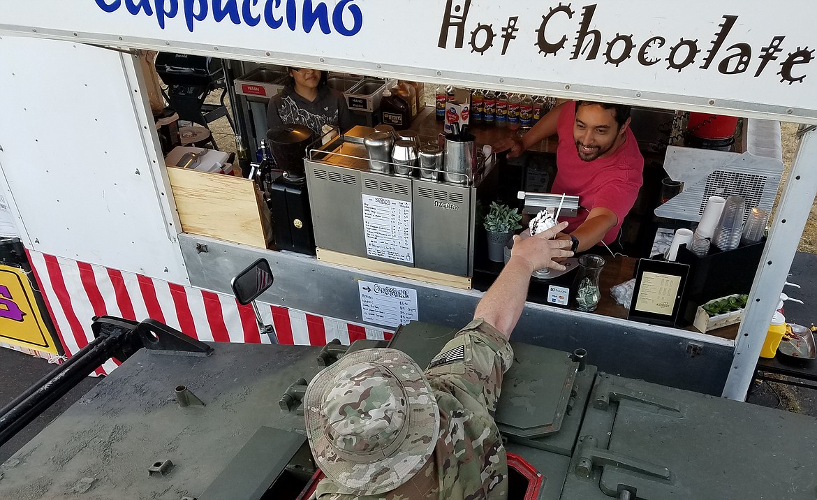 Julia and Jim Hossack use their demilitarized vehicle to stop for a roadside treat. The Hossacks brought their fixed-up British FV433 Abbot 105 mm self-propelled gun to the Rathdrum Days Parade.