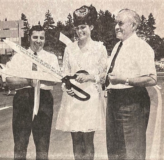 Linda Dreschel, with chamber president Roger Carlson, left, and Mayor Larry Gardner, cuts the ribbon to open the new U.S. 95 bridge over the Spokane River.