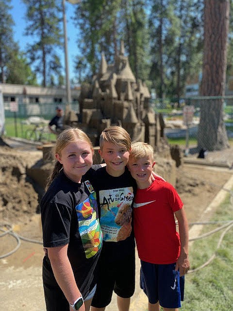 From left, Kenzie Rix, Declan Rider and Rory Rider smile for the camera in front of the iconic Art on the Green sandcastle at the 2022 festival. This year's Art on the Green begins Aug. 4 and goes through Aug. 6 on the North Idaho College campus.