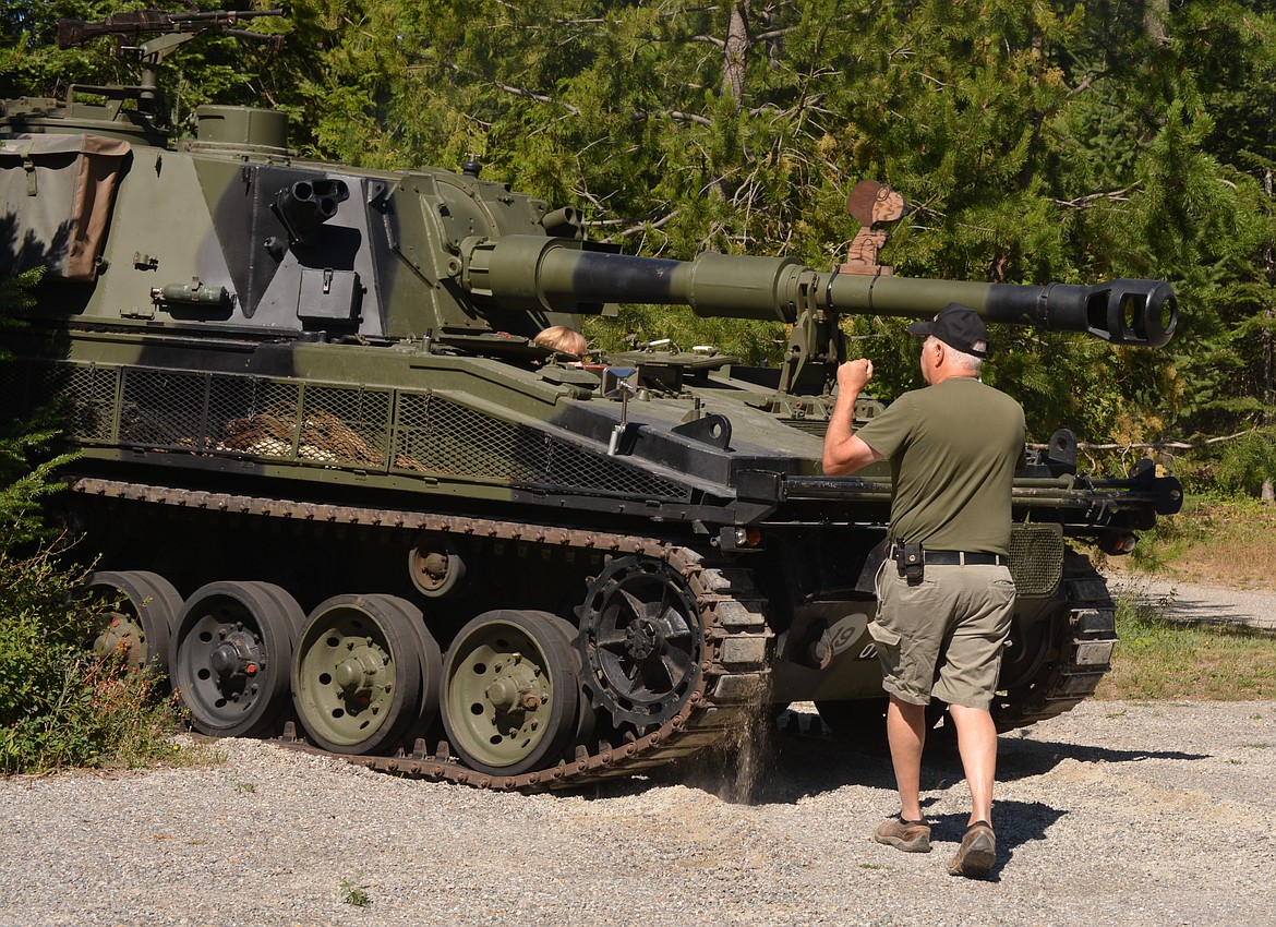 Jim Hossack directs Julia Hossack as she drives a self-propelled vehicle on their property in Rathdrum. The couple fix up demilitarized vehicles and bring them as attractions to local parades. Their British FV433 Abbot 105 mm self-propelled gun rode in the Rathdrum Days Parade. (CAROLYN BOSTICK/Press)