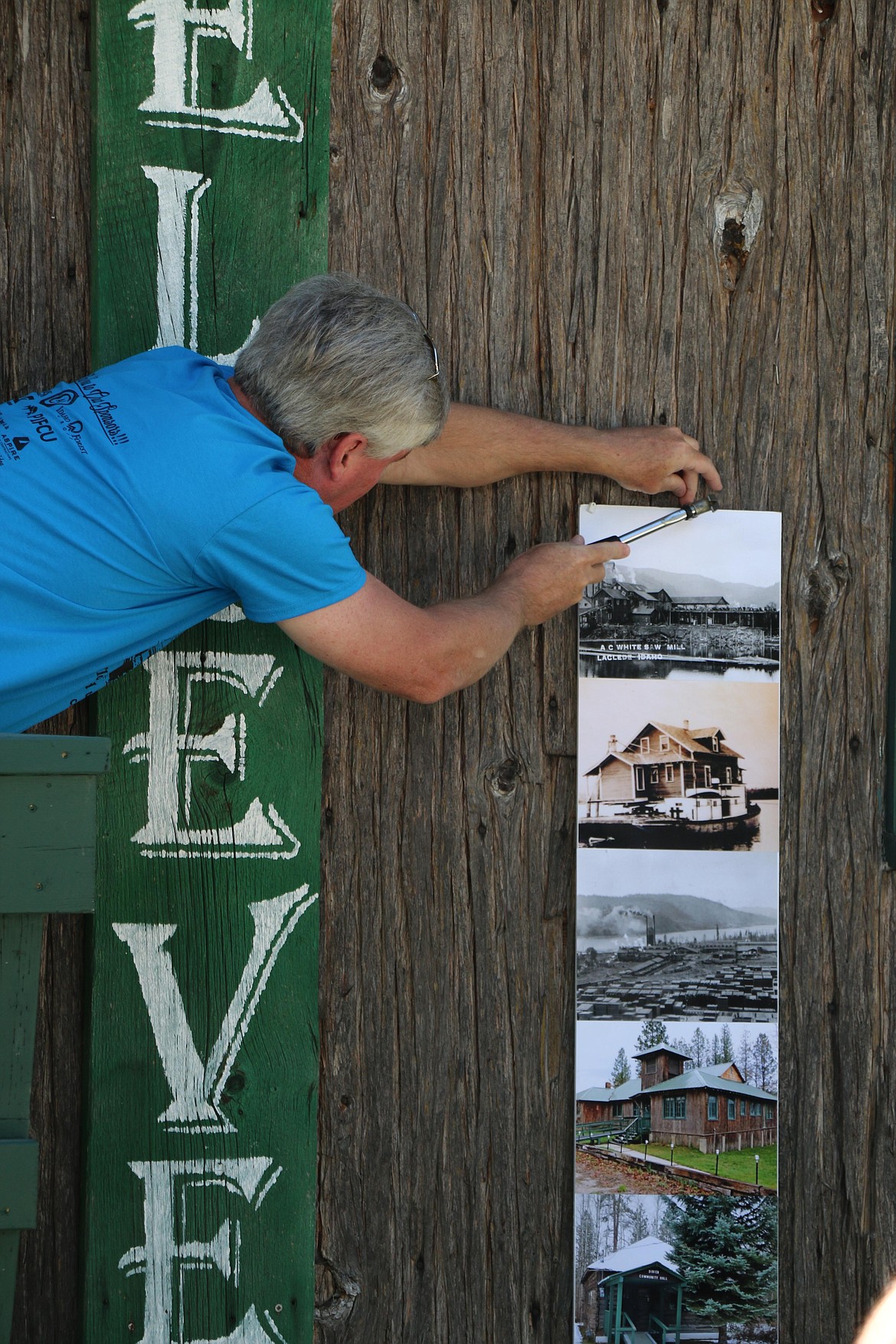 A Dover resident puts up a display of historic photos showing Dover's early days in preparation for a community barbecue.