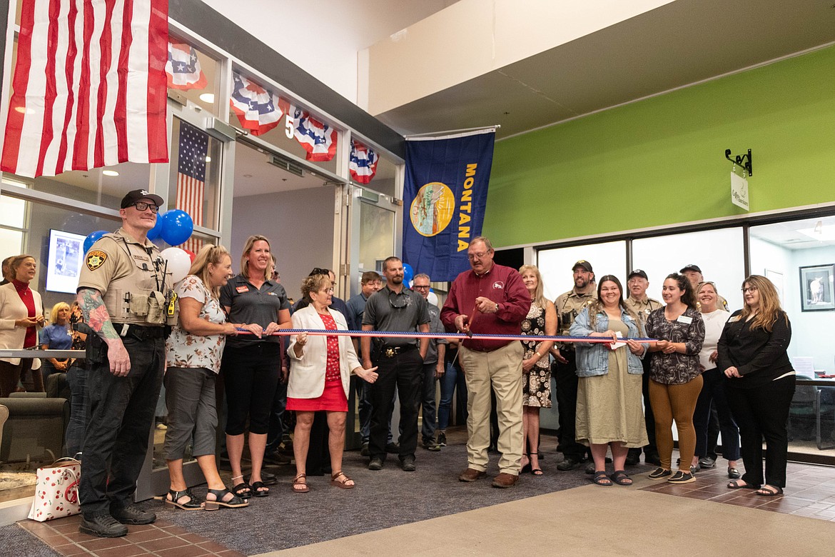 Marquis Laude, the president of Integrated Security Solutions, Inc., cuts the ribbon at the company's new location at Gateway Mall in Kalispell. (Kate Heston/Daily Inter Lake)