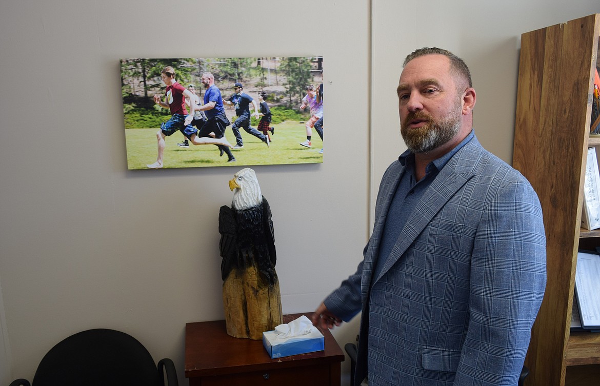 Soap Lake Superintendent Aaron Chavez gestures to a chainsaw wood carving of a bald eagle that he carved, which he intends to use, along with other carvings, as awards for students, staff, and community members that personify the best of Soap Lake schools.