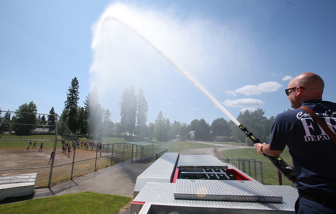 Coeur d'Alene Fire Capt. Nate Hyder hoses students with 500 gallons of water Thursday during a fire engine visit to Fernan STEM Academy on the final day of the 2023 CDA Reads program. Nearly 160 kindergarten-through-fifth graders attended the literacy intervention camp this summer with more than 80 middle school mentors to assist them with their reading needs.