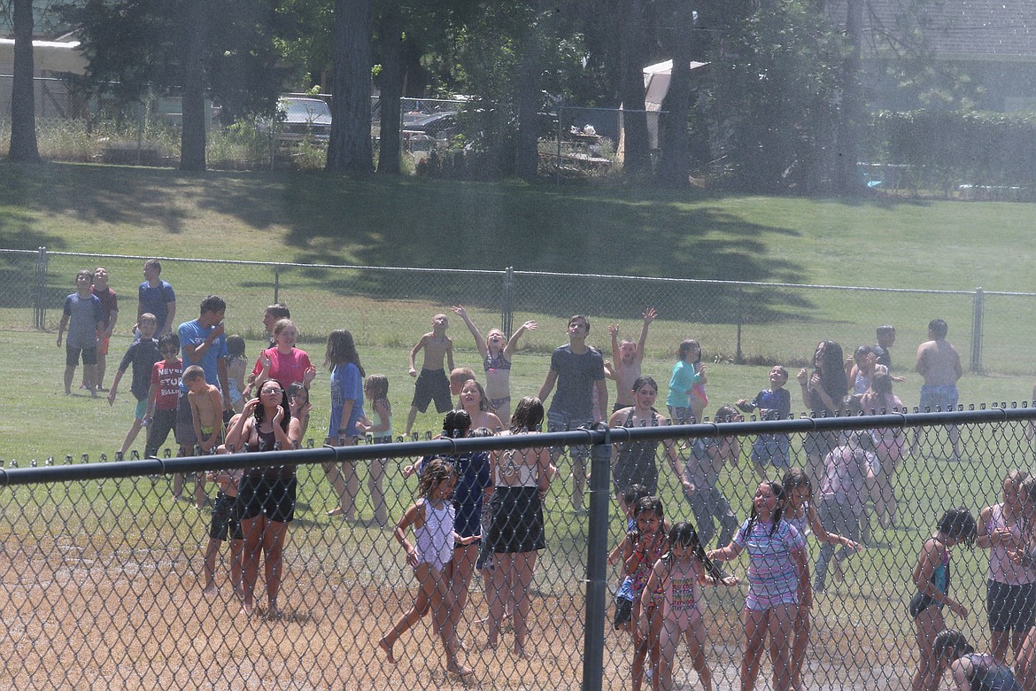 Kids are elated to be sprayed with water from a Coeur d'Alene Fire engine Thursday on the last day of the CDA Reads program at Fernan STEM Academy.