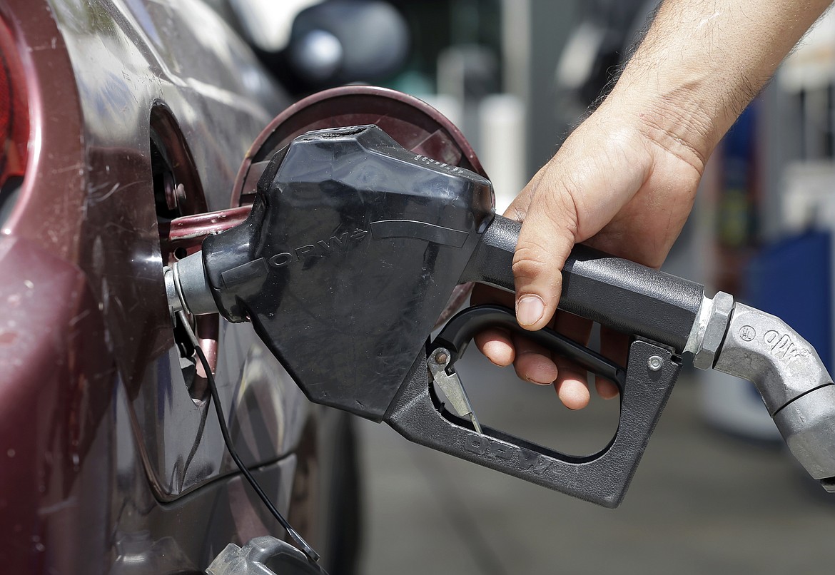 FILE - A customer puts gas in their vehicle, June 28, 2016, in Miami. The U.S. government wants to raise the fuel economy of new vehicles 18% by the 2032 model year so the fleet would average about 43.5 miles per gallon in real world driving. The proposed numbers were released Friday, July 28, 2023, by the National Highway Traffic Safety Administration, which eventually will adopt final mileage requirements. (AP Photo/Alan Diaz, File)