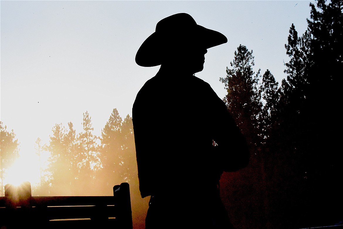 A cowboy takes in the competition at Saturday evening's Kootenai River Stampede rodeo at J. Neils Memorial Park in Libby. (Scott Shindledecker/The Western News)