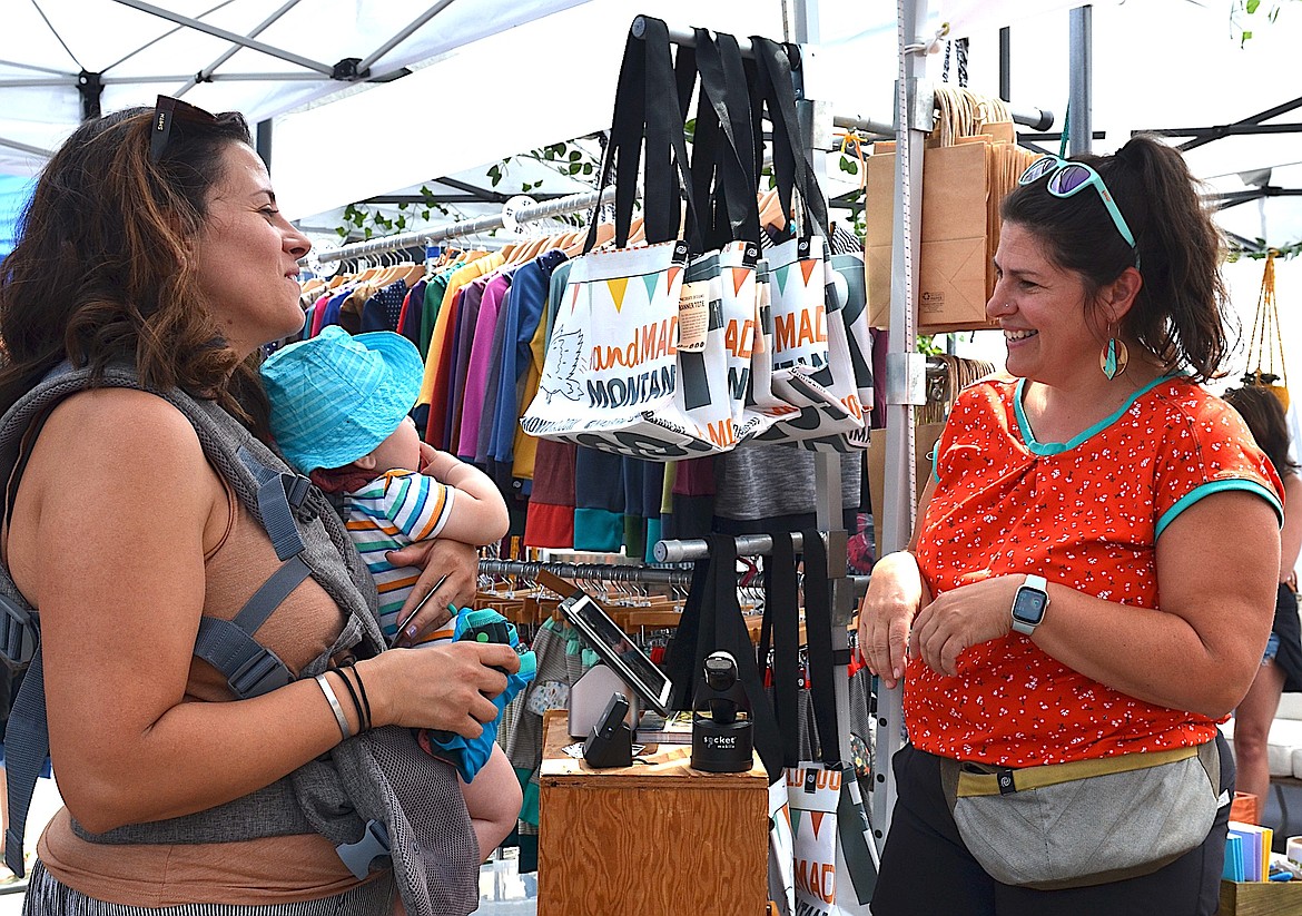 Carol Lynn Lapotka, chair of this year's Flathead Cherry Festival, visits with a customer at her handMADE Montana booth. (Kristi Niemeyer/Leader)