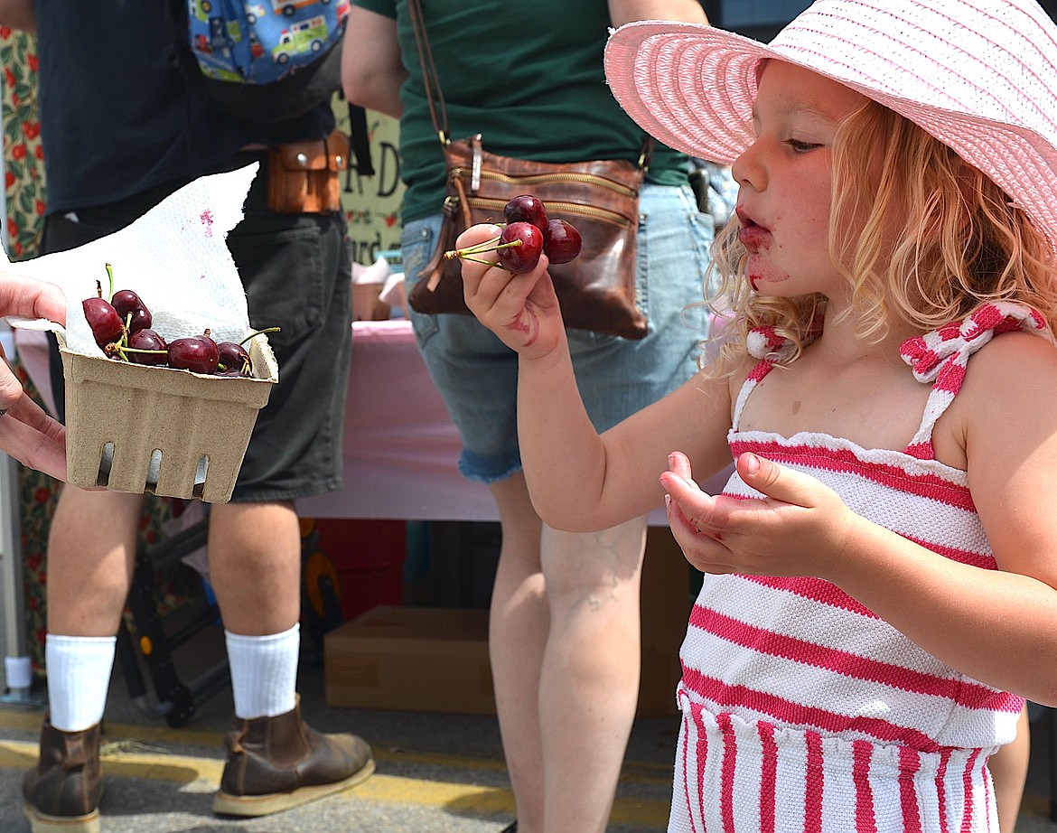 Scarlet Dillavou blissfully devours a handful of cherries at last year's Flathead Cherry Festival. (Kristi Niemeyer/Leader)