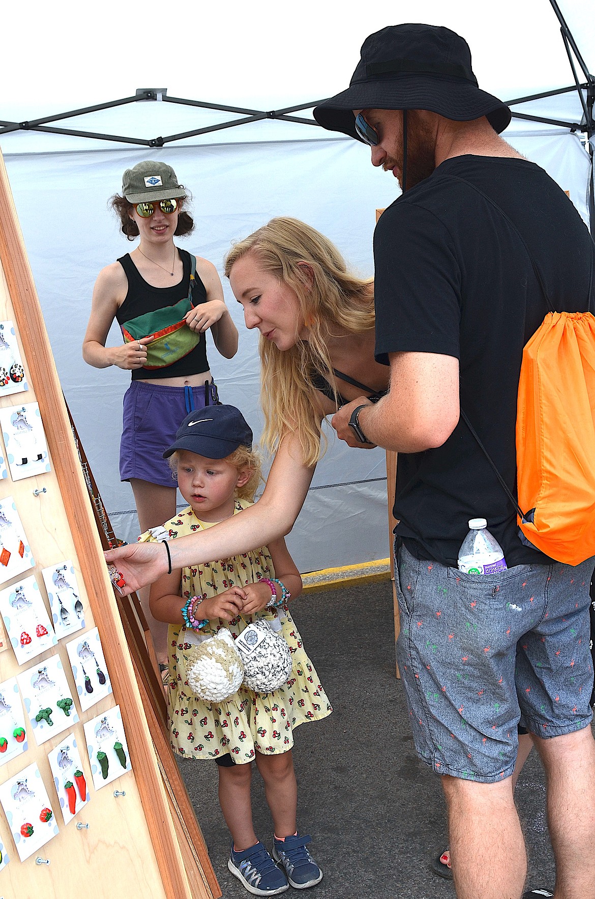 Pair of earring shoppers visits? booth at the Flathead Cherry Festival in Polson. This year's event featured booths by 150 artisans. (Kristi Niemeyer/Leader)