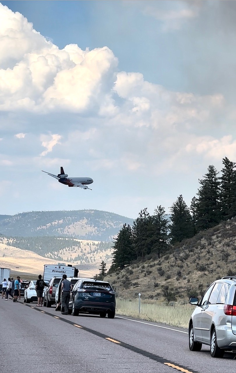 Vehicles stop along Montana 28 west of Elmo as air resources fly over the Niarada Fire on Sunday, July 30, 2023. (Mackenzie Gress photo)