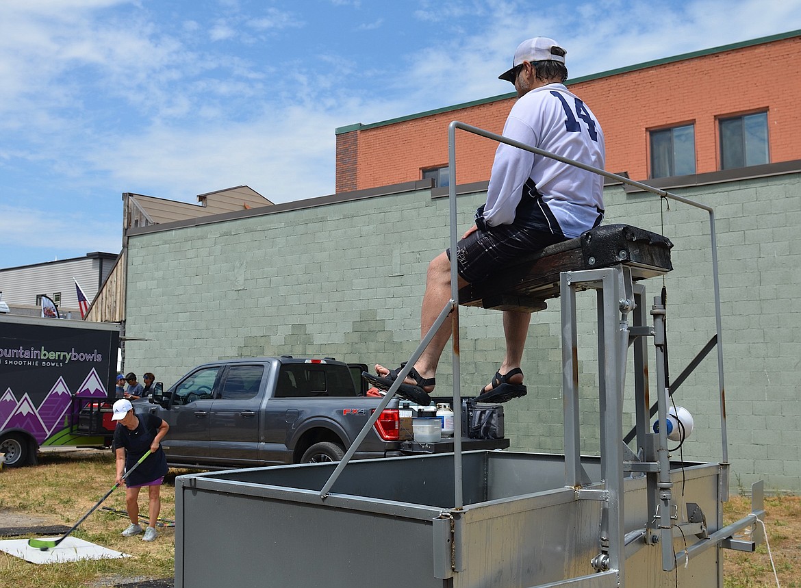 Mike Lozar of Mission Valley Ice Arena prepares for the inevitable dunk, delivered by a well-aimed puck, during Saturday's arena fundraiser, held during the Flathead Cherry Festival. (Kristi Niemeyer/Leader)