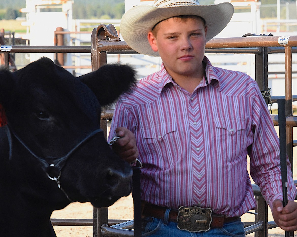 4-Her Cooper Wayman and his steer Walt (after Walt Longmire) wait for a turn in the auction ring. (Berl Tiskus/Leader)