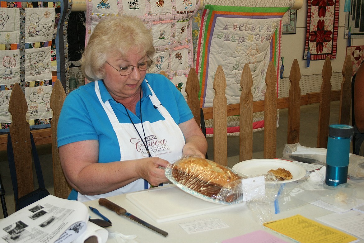 Baking judge Terri Holben unwraps an entry in the baking contest at the Grant County Fair last year. This year's fair includes many traditional contests like baking, but it also includes a healthy music lineup.