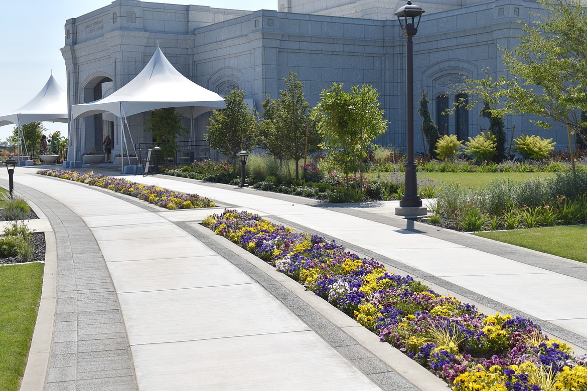The temple grounds are carefully landscaped with wide walkways and planters full of color flowers.