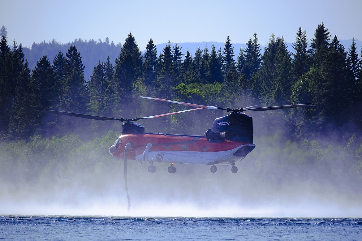 A type 1 firefighting helicopter hovers above Whitefish Lake to refill water in an effort to fight the North Lake wildfire on Monday. (Joseph Raudabaugh photo)