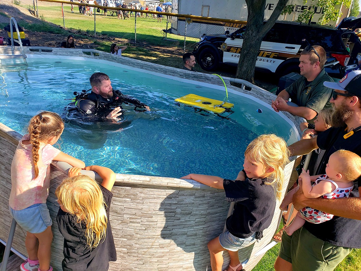 Sheriff's Deputy Kurtis Didier talks to onlookers about the dive team and equipment he gets to use when conducting dives.