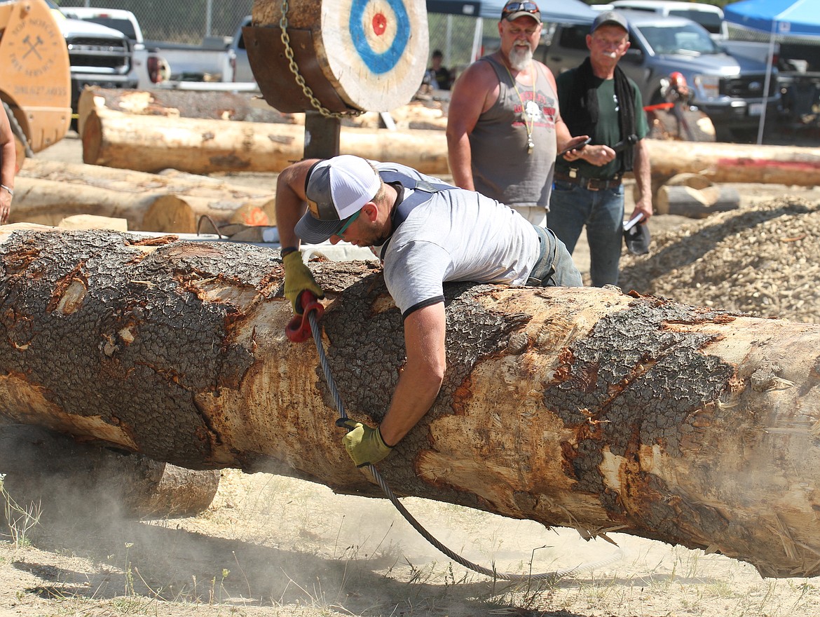 A logger finishes a choker race, part of the Timber Days logging competition. A choker race is where loggers carry a choker (a flexible cable used for hauling logs) through an obstacle course and then return to the start to reattach the choker.