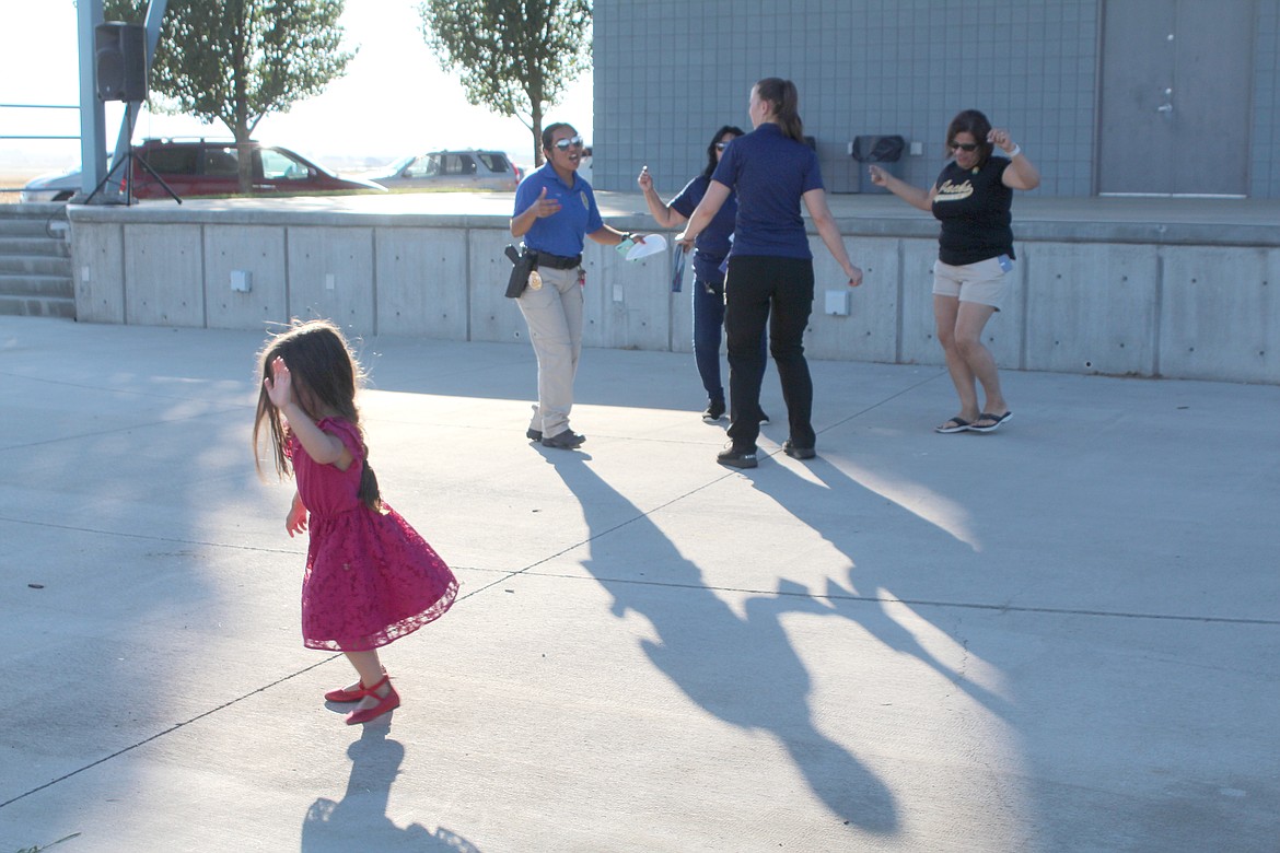 Quincy Police Department staff rock out to the music during National Night Out Monday, joined by a small bystander.