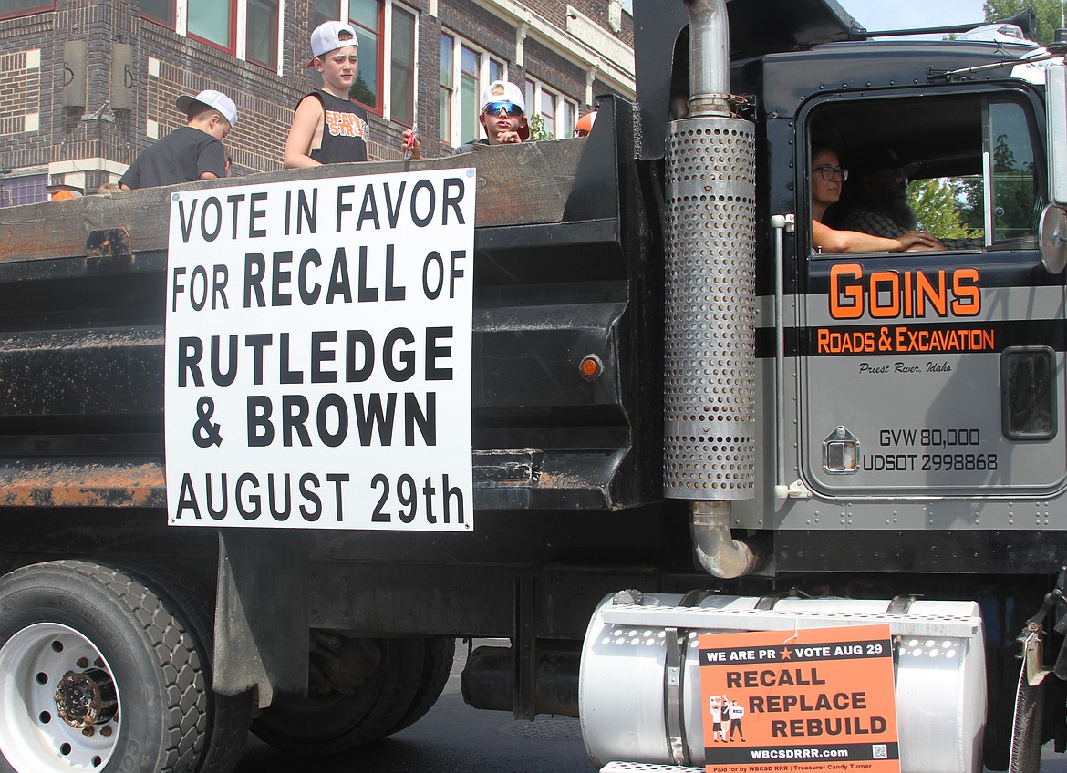 A construction vehicle makes its way down High Street with a sign encouraging others to vote for a recall against two West Bonner County School District Board members.