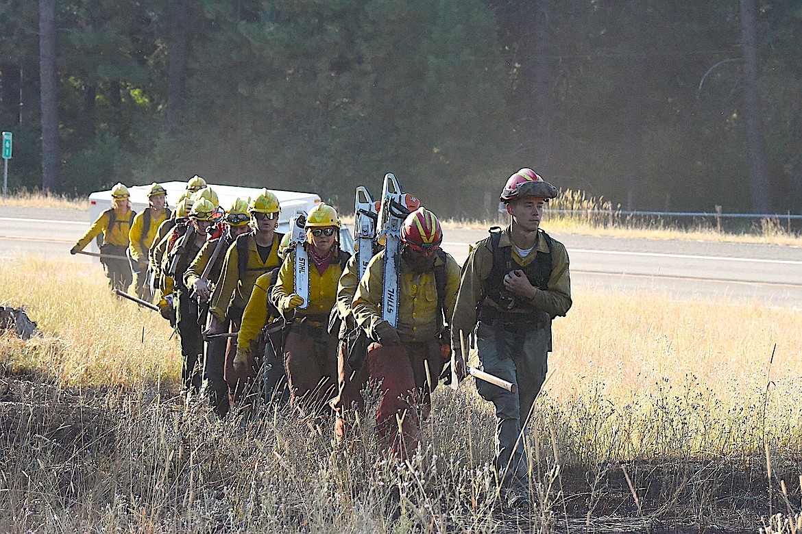 Firefighters from the Rocky Mountain Fire Company begin their trek to build fire lines Wednesday morning at the Gravel Pit Fire off U.S. 2 near Silver Butte Road in Lincoln County. (Scott Shindledecker/The Western News)