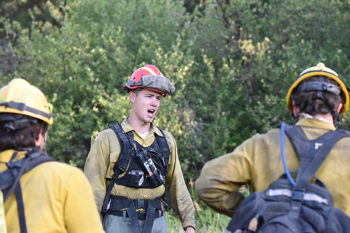 Rocky Mountain Fire Company squad leader Mathias Gross gives instructions Wednesday morning at the Gravel Pit Fire off U.S. 2 near Silver Butte Road in Lincoln County. (Scott Shindledecker/The Western News)