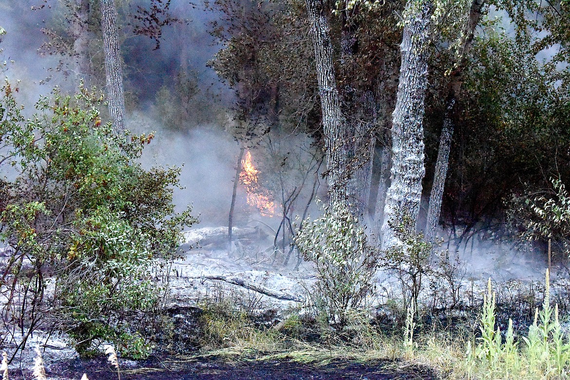 Flames and ash from the Gravel Pit Fire Wednesday morning off U.S. 2 near Silver Butte Road in Lincoln County. (Scott Shindledecker/The Western News)