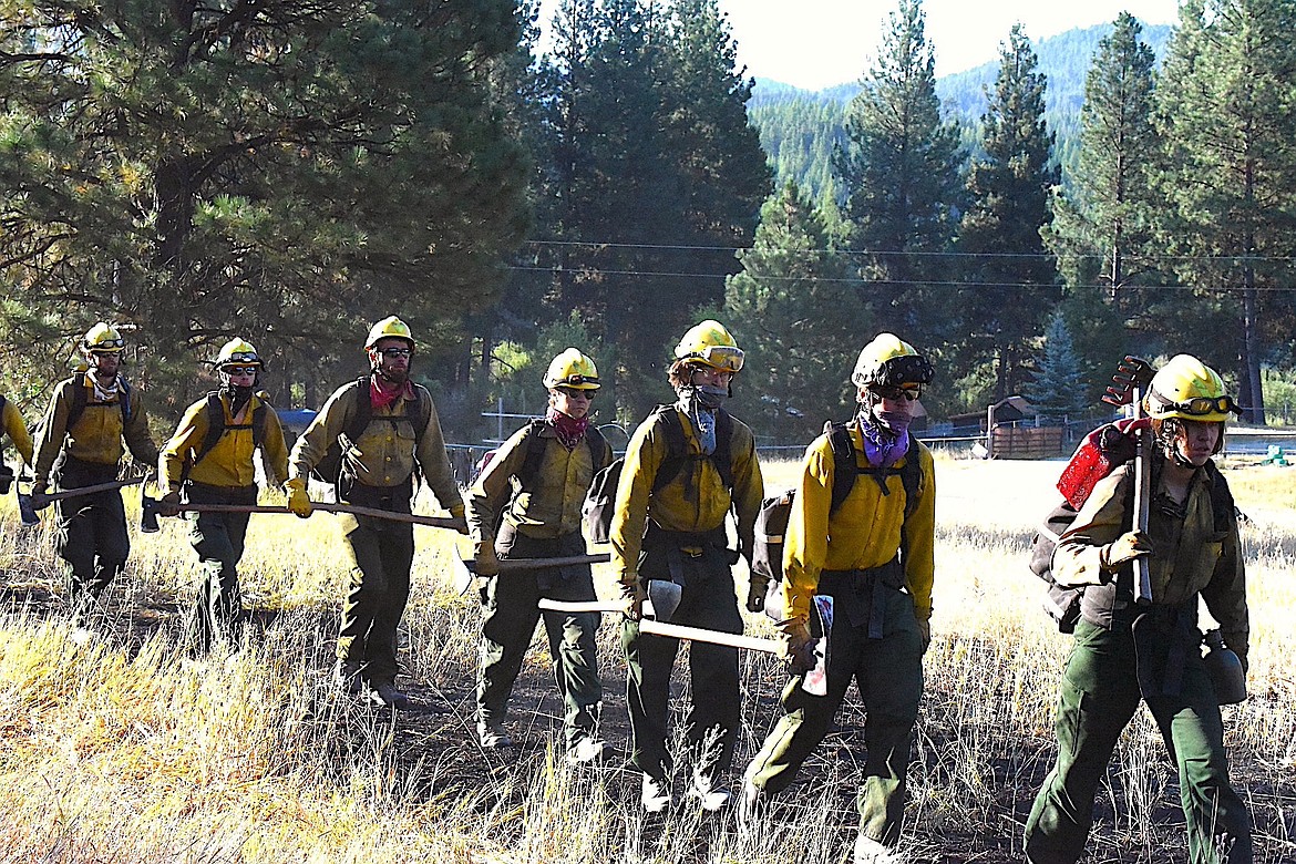 Firefighters from the Rocky Mountain Fire Company begin their trek to build fire lines Wednesday morning at the Gravel Pit Fire off U.S. 2 near Silver Butte Road in Lincoln County. (Scott Shindledecker/The Western News)