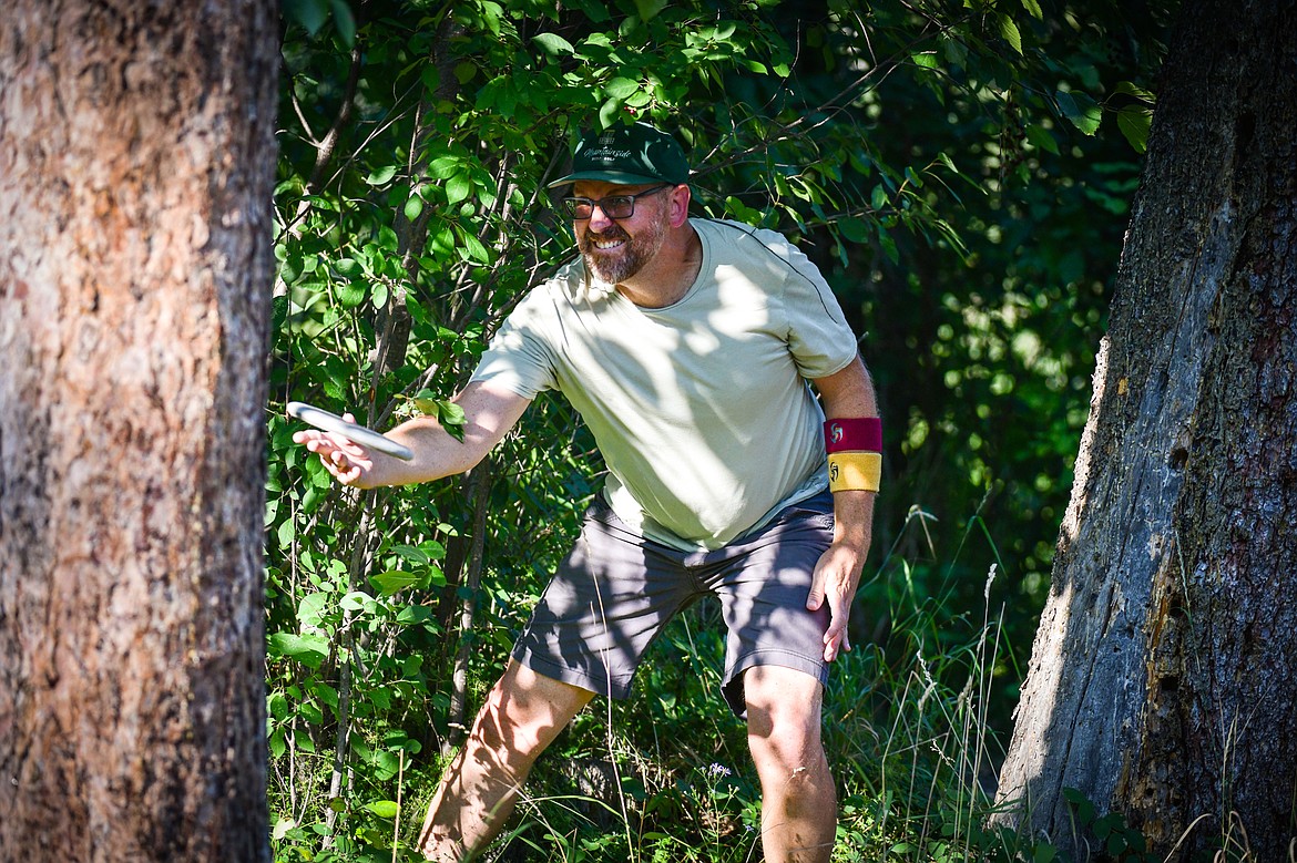 Isaac Bromberg throws his approach disc from the "rough" during a round a Flathead Valley Disc Golf round at Lawrence Park in Kalispell on Tuesday, Aug. 1. (Casey Kreider/Daily Inter Lake)