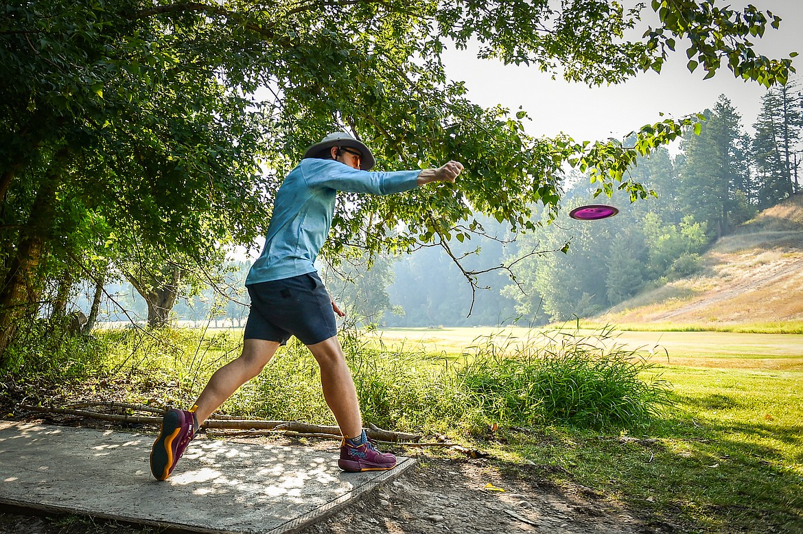 Max Dwyer throws his driver disc during a Flathead Valley Disc Golf round at Lawrence Park in Kalispell on Tuesday, Aug. 1. (Casey Kreider/Daily Inter Lake)