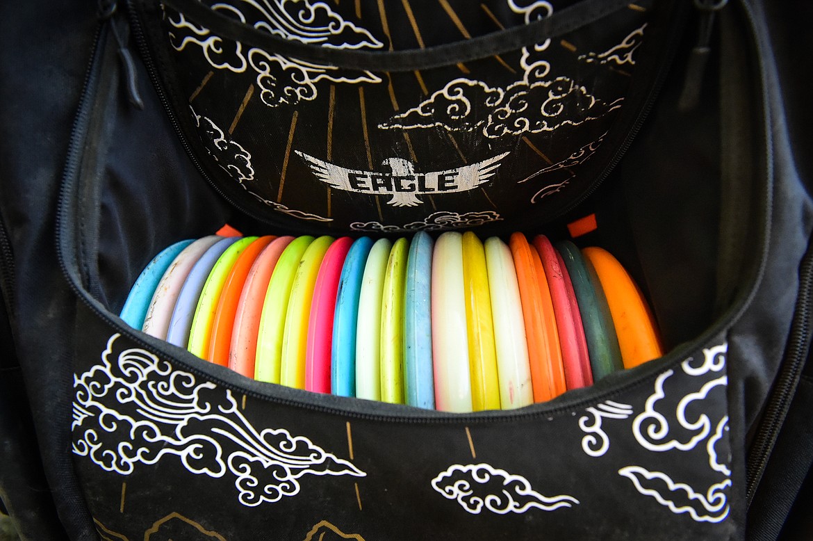 Disc golfers carry a variety of discs, much like a bag of golf clubs, to cover all the different lengths and types of throws needed on a disc golf course. (Casey Kreider/Daily Inter Lake)