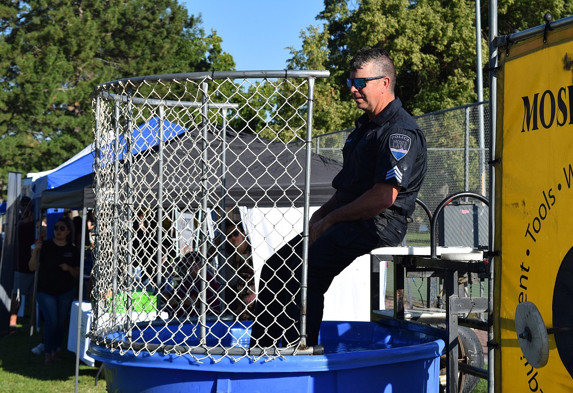 A Moses Lake Police Officer waits to be dunked in a water tank by children throwing balls at a target connected to the officer’s seat. The dunking station was operated throughout the event, along with a number of other children’s games.