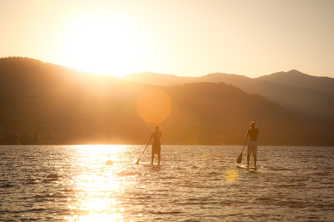 Paddle boarders enjoy Lake Chelan, one of the major tourist destinations in Washington.