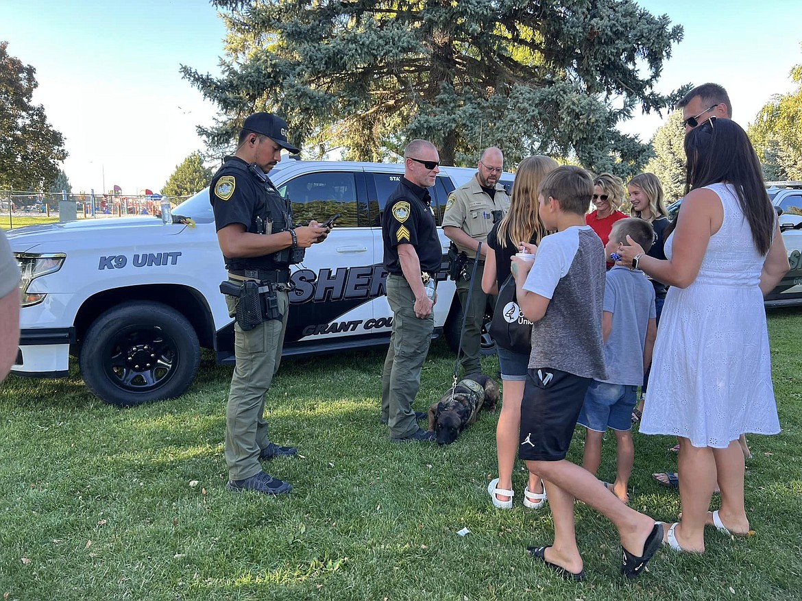 Grant County Sheriff's Office personnel, including a sleepy K9 unit, speak with community members during the Moses Lake Police Department's National Night Out event earlier this week.