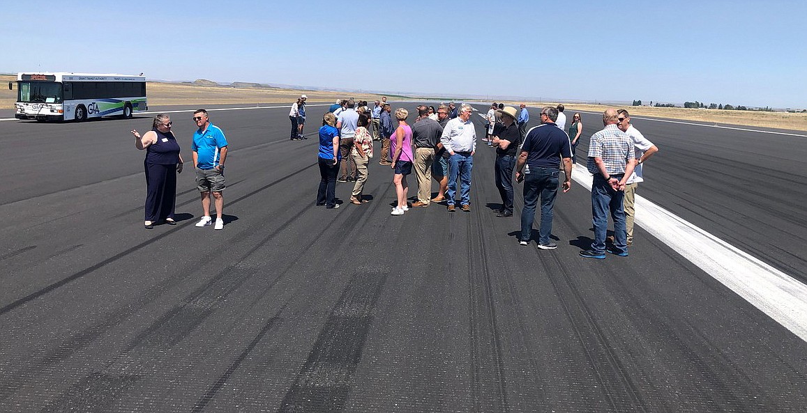 Attendees at the Port of Moses Lake tour Wednesday stand on the main runway at Grant County International Airport. At 13,503 feet, the runway is one of the longest civilian runways in America.