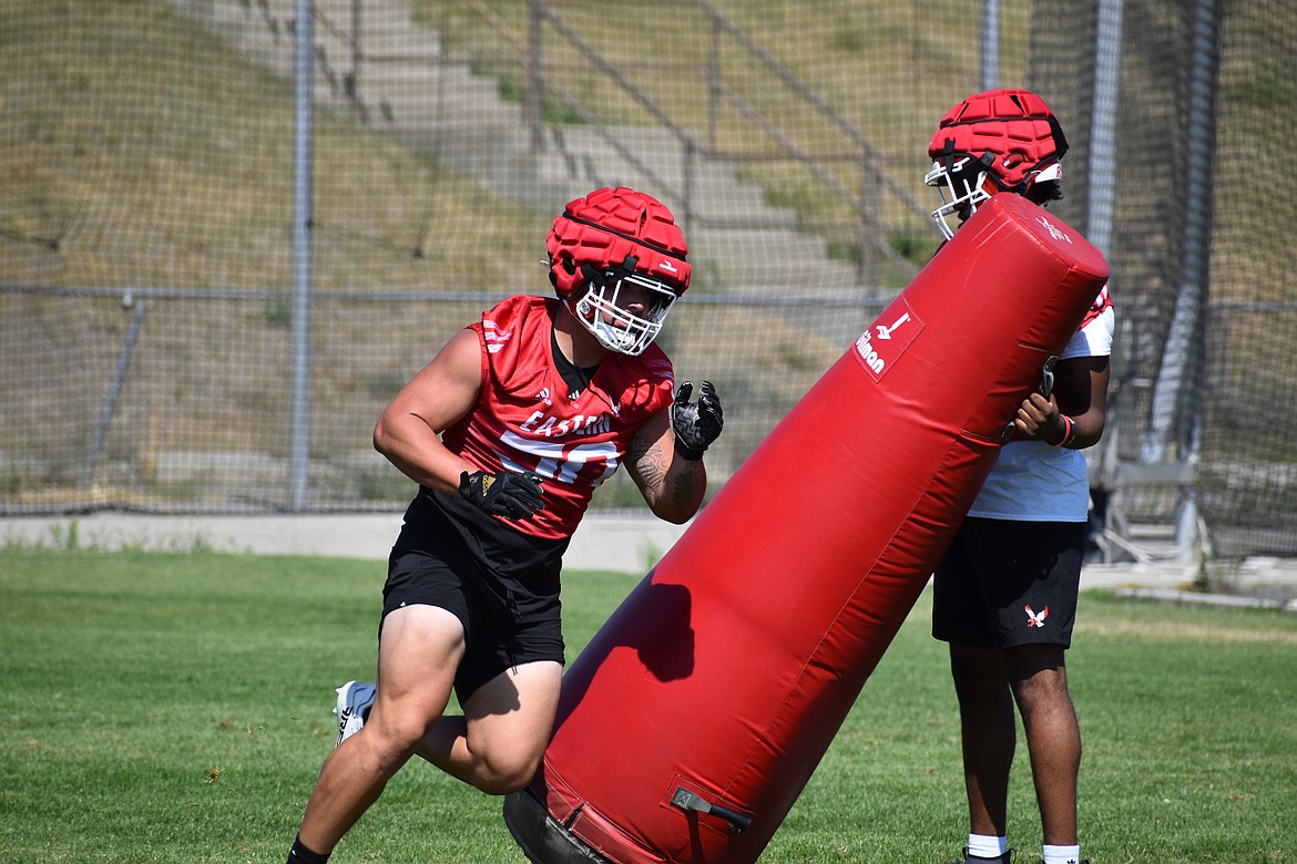 Eastern Washington defensive lineman Isaiah Perez pushes over a tackling dummy during a drill at Thursday’s practice in Cheney.