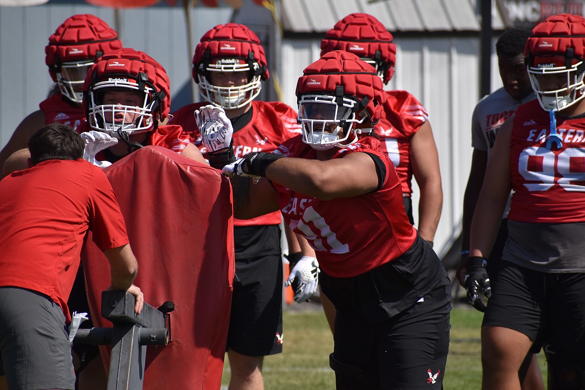 The Eastern defensive line unit works with a blocking sled at practice on Thursday.