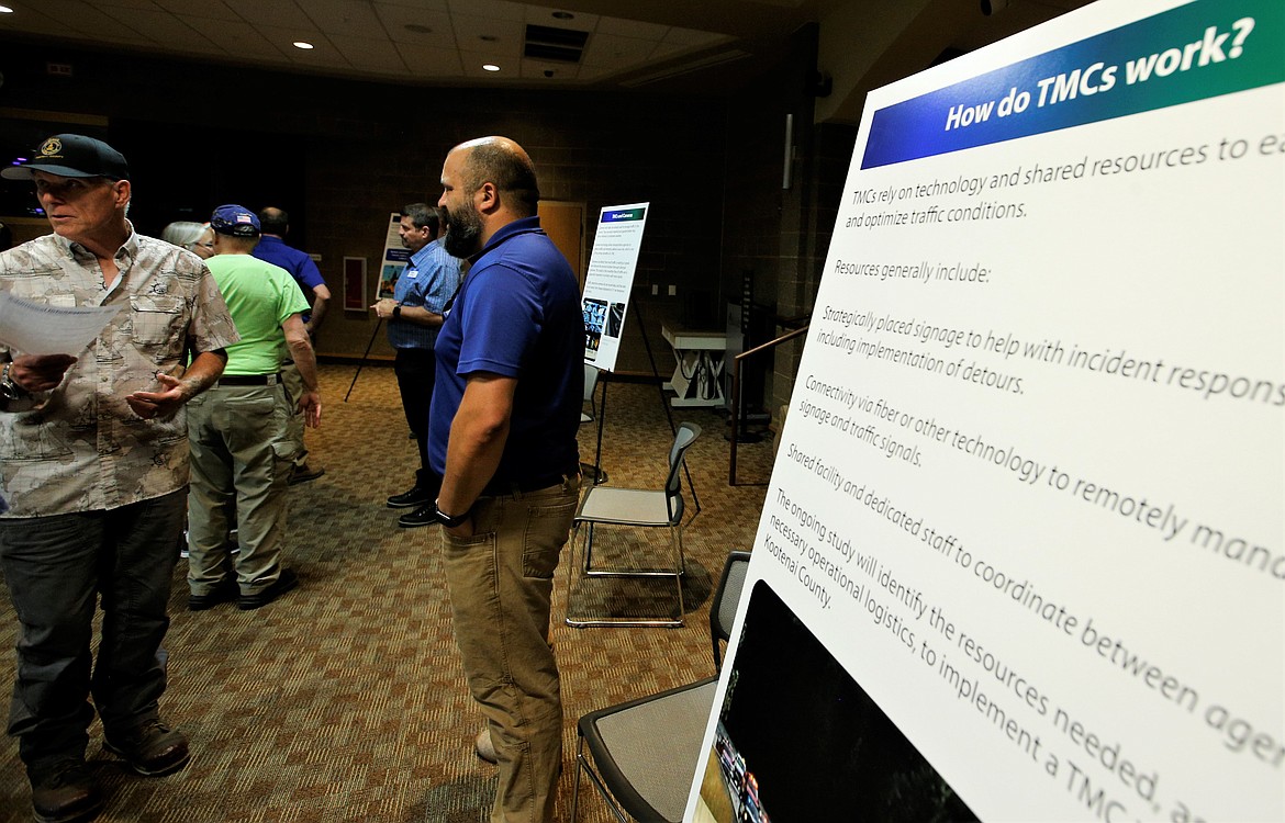 Nathan Herbst, traffic engineer with the Idaho Transportation Department, center, speaks with visitors during an open house in the Coeur d'Alene Public Library Community Room on Thursday.