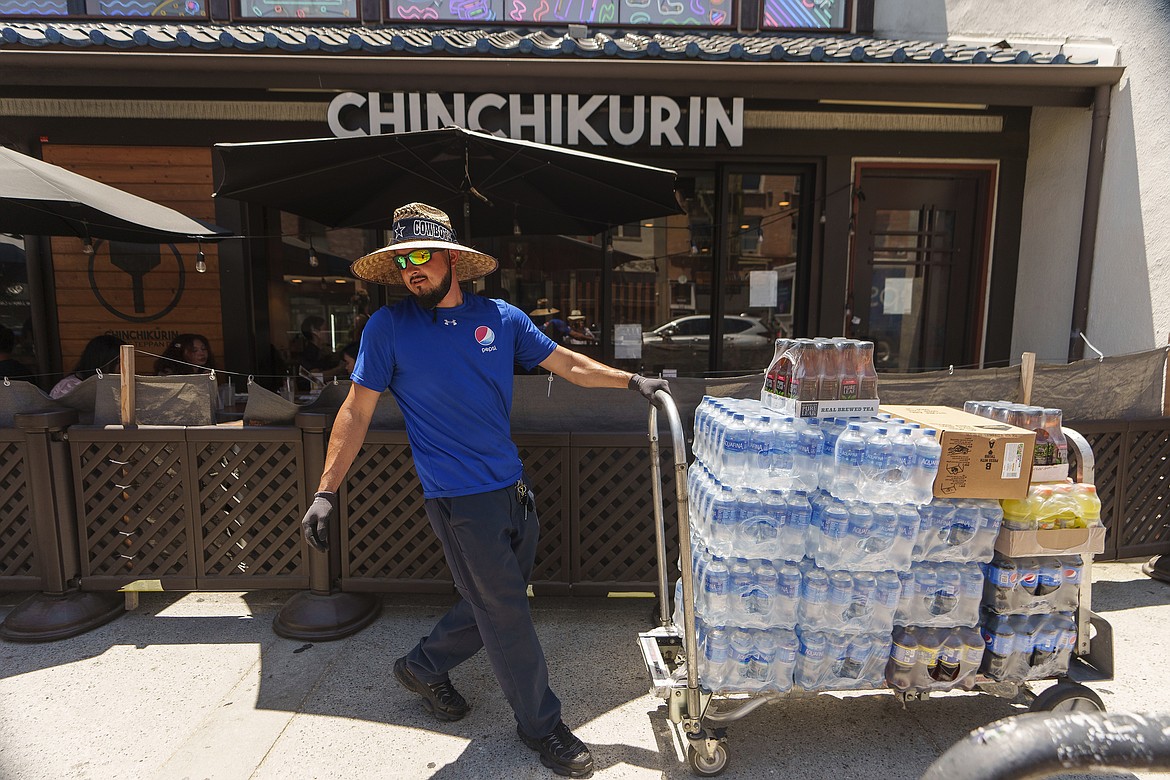 File - Driver Jose Viveros delivers beverages in the Little Tokyo district of Los Angeles, Thursday, July 27, 2023. On Friday, the U.S. government issues the July jobs report. The labor market has added jobs at a steady clip in the past year, despite efforts by the Federal Reserve to cool the economy. (AP Photo/Damian Dovarganes, File)