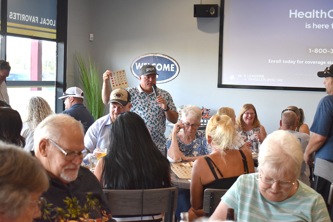 Grant County Sheriff Joe Kriete explains to a crowd of bingo players how to win the next round by filling in an L pattern on their bingo cards.