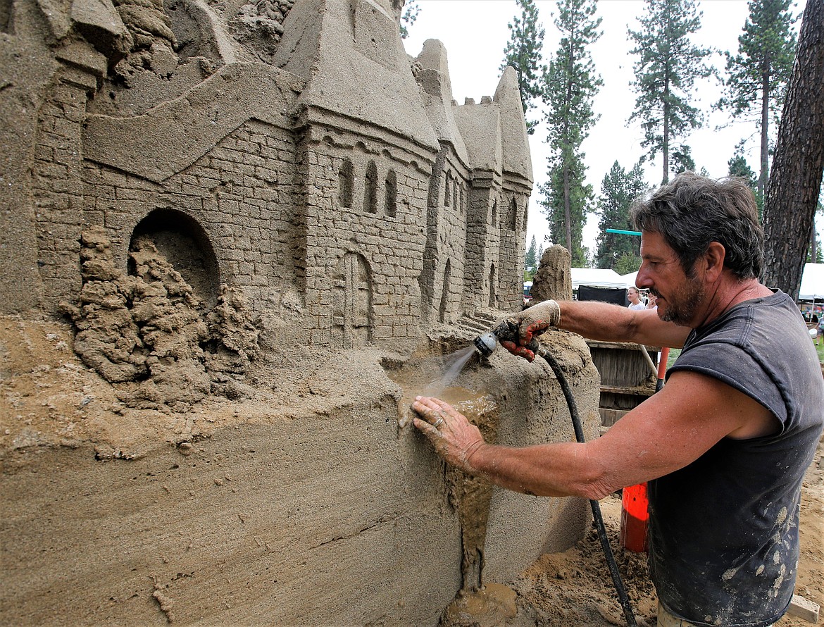 Scott Dodson works on a sand castle during Art on the Green on Friday.