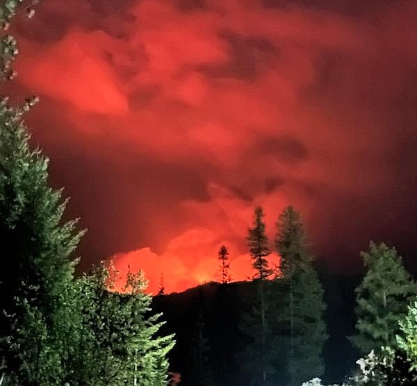 Flames from the Ridge Creek Fire glow just just beyond a ridge on Saturday night.