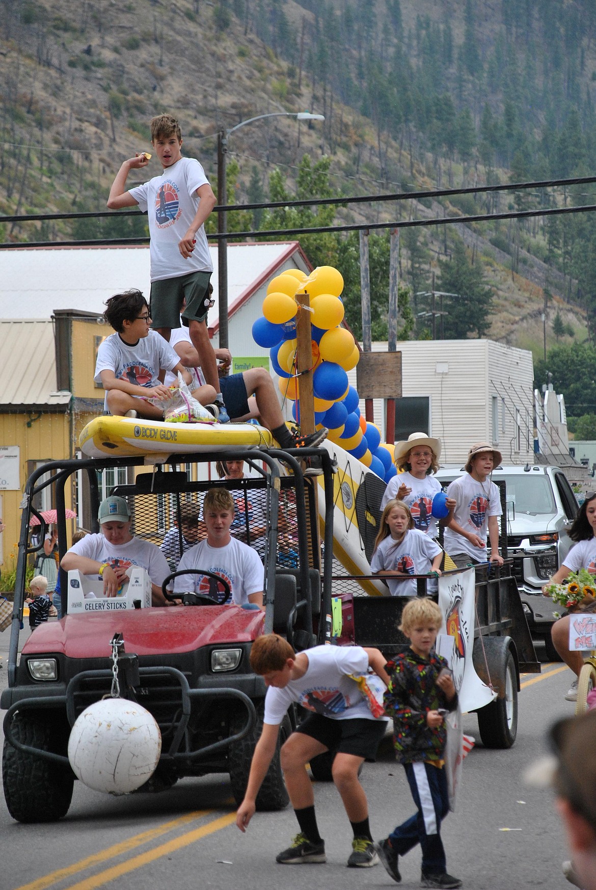 Henry Hanson, standing, pitches some candy to the crowd from the Mineral County Recreation Club Paddle Board Race float. (Mineral Independent/Amy Quinlivan)