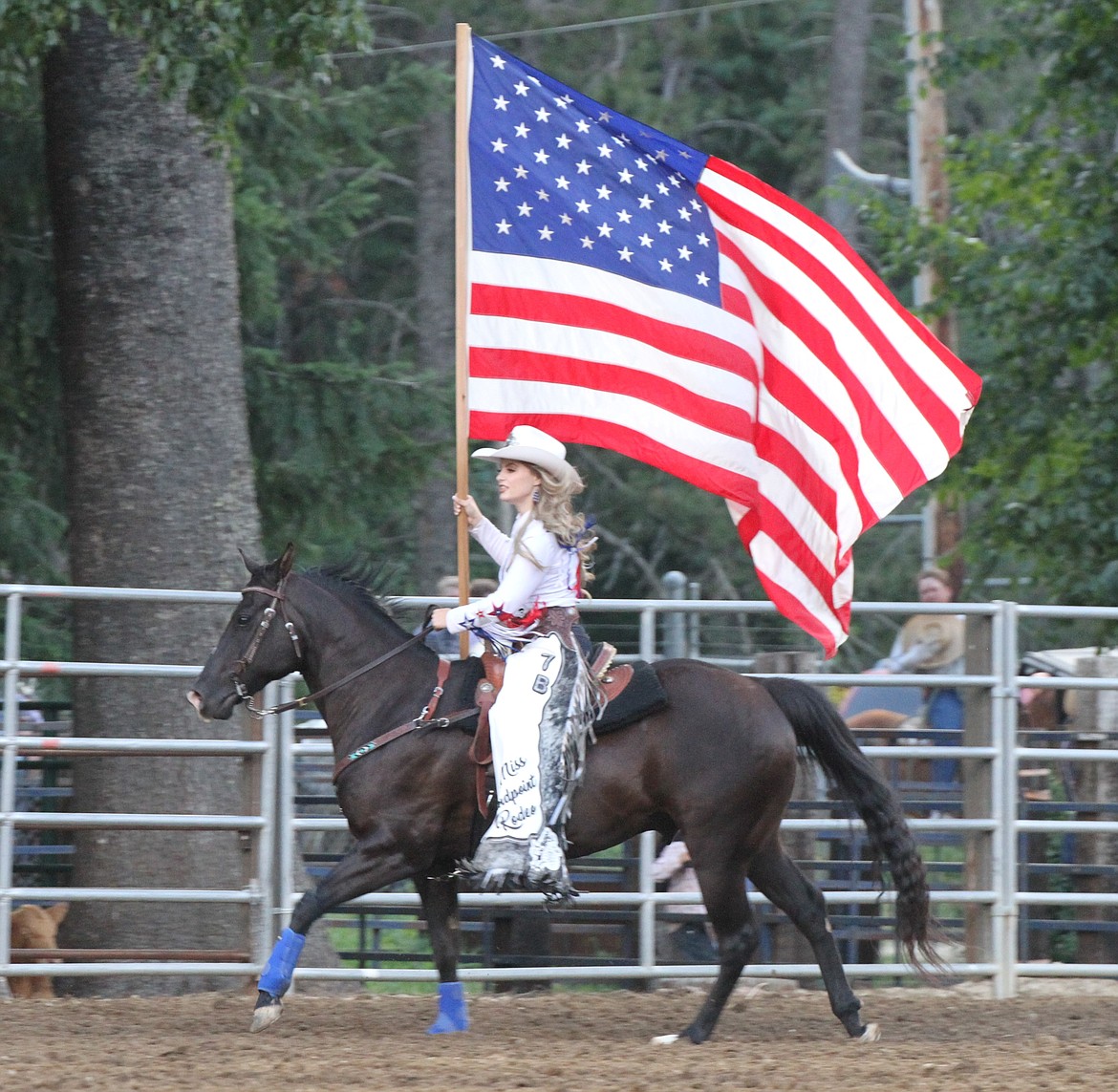 Miss Sandpoint Rodeo, Maddie Gunter, carries the American flag around the arena during the opening ceremonies.