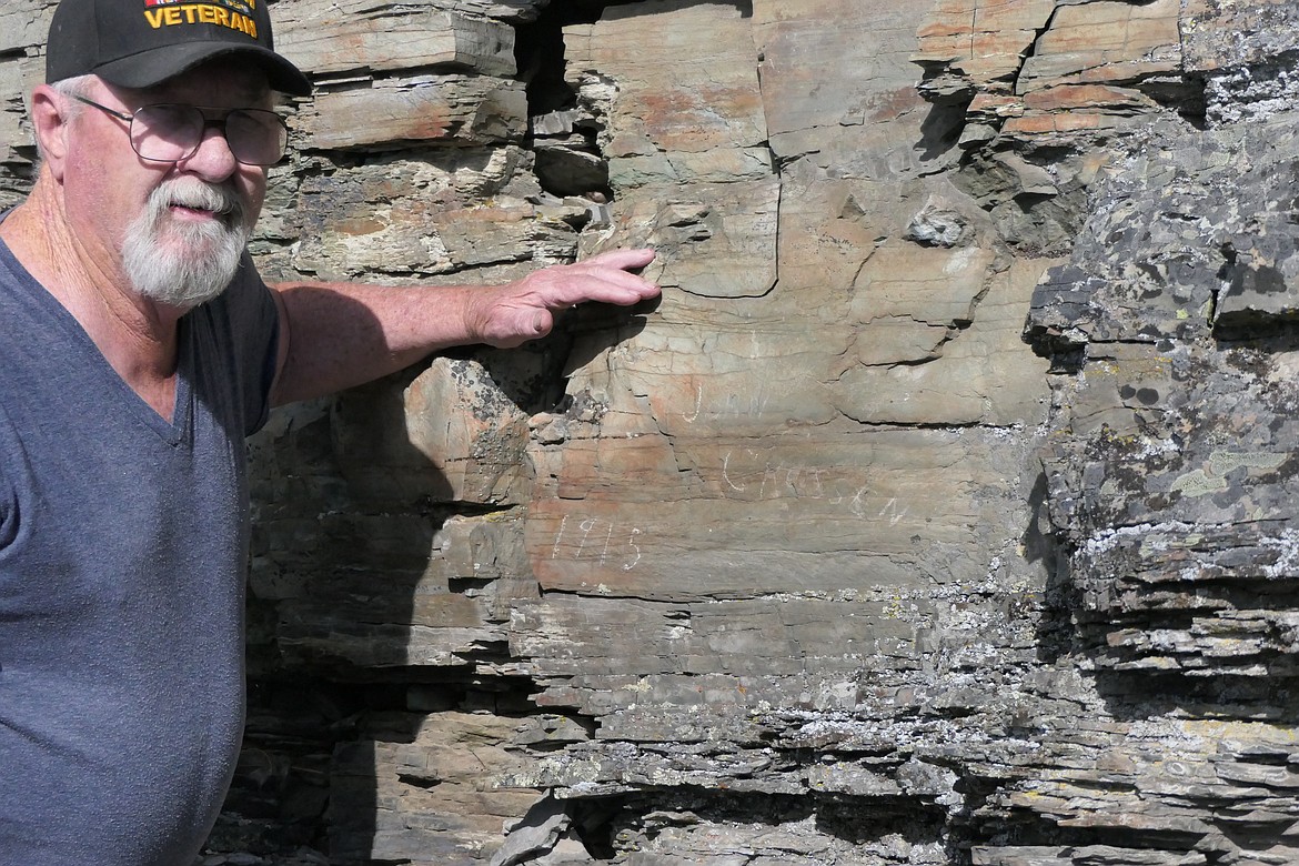 Plains area resident Ed Farmer stands near the rock ledge into which "John Crossen 1915" was carved. (Chuck Bandel/VP-MI)