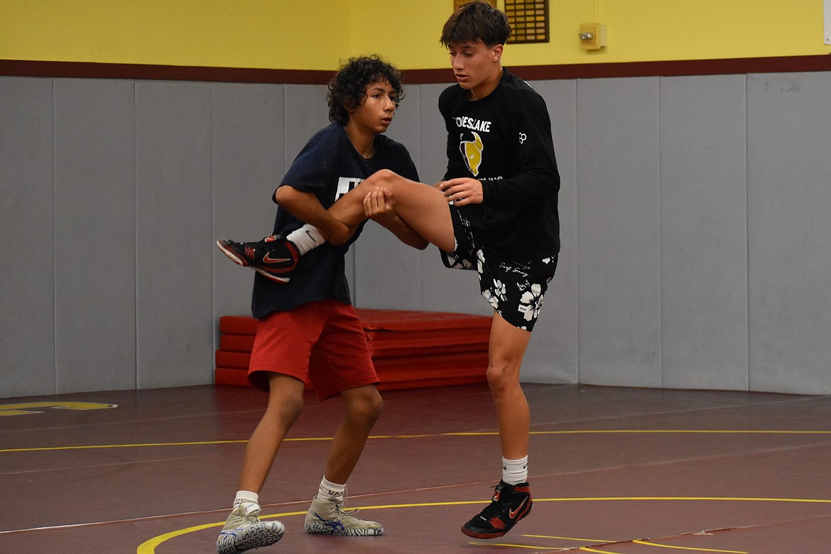 A pair of wrestlers work on a takedown move at Saturday’s Chasing Gold Camp at Moses Lake High School.