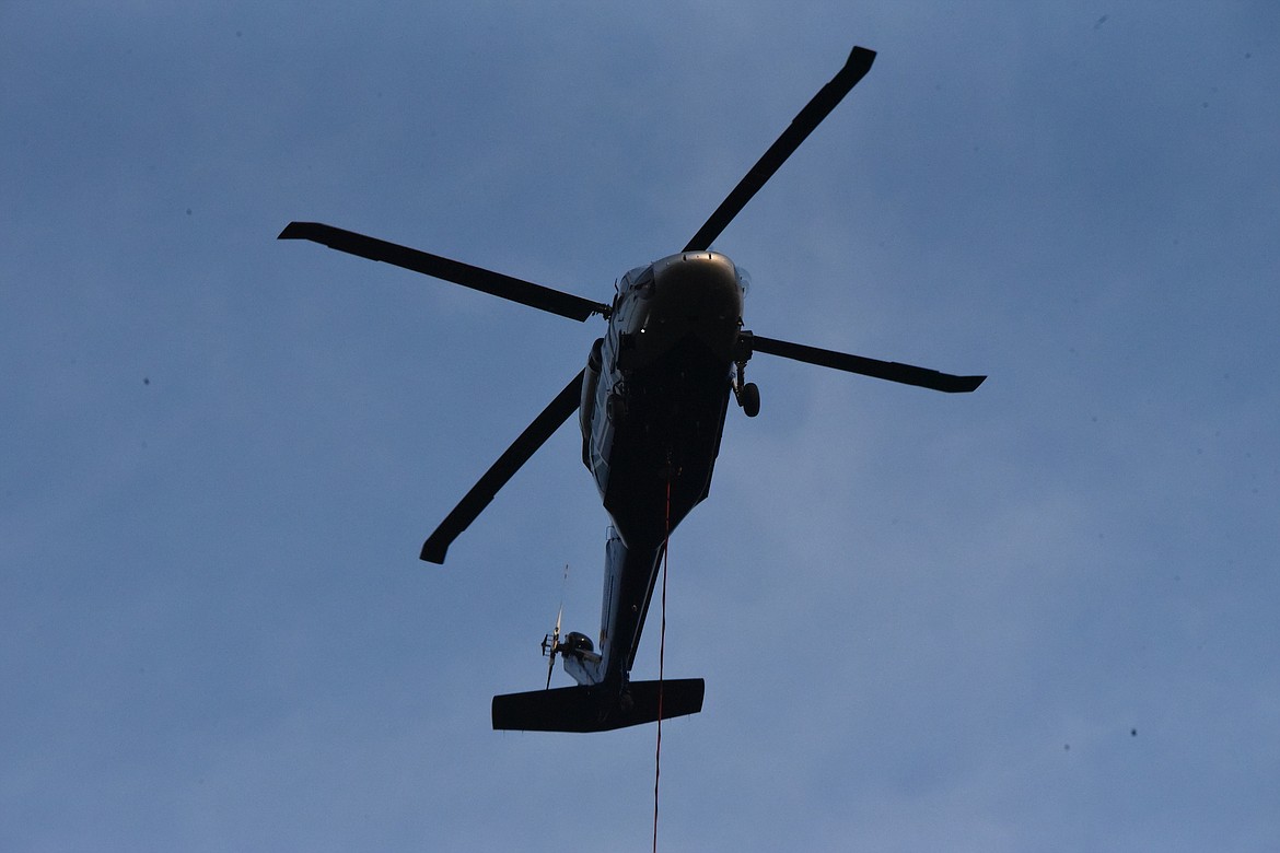 A helicopter heads to the Kootenai River in Libby to get water to dump on wild fires on Swede Mountain on Monday evening, Aug. 7. (Scott Shindledecker/The Western News)