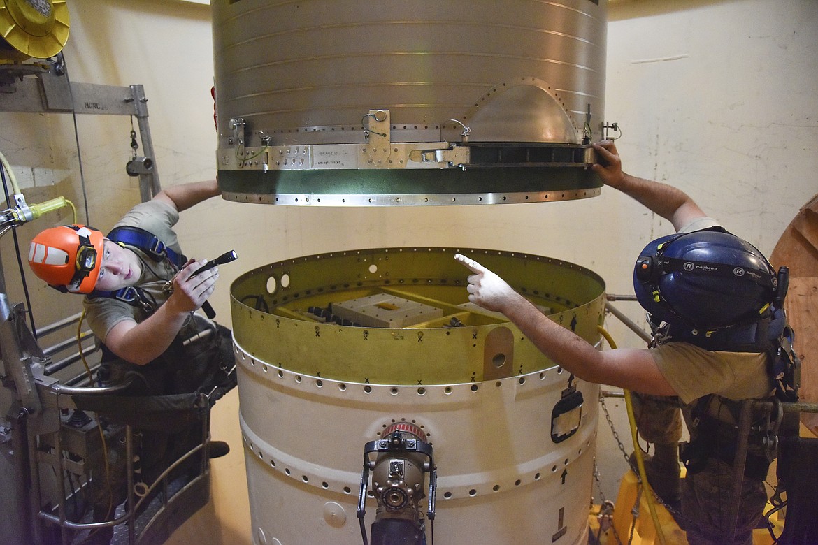 In this image provided by the U.S. Air Force, Airman 1st Class Jackson Ligon, left, and Senior Airman Jonathan Marinaccio, 341st Missile Maintenance Squadron technicians connect a re-entry system to a spacer on an intercontinental ballistic missile during a Simulated Electronic Launch-Minuteman test Sept. 22, 2020, at a launch facility near Malmstrom Air Force Base in Great Falls, Mont. The Air Force has temporarily closed two nuclear launch facilities after finding unsafe levels of a likely carcinogen in air samples at a Montana missile base where a striking number of men and women who served have reported cancer diagnoses. (Senior Airman Daniel Brosam/U.S. Air Force via AP, File)