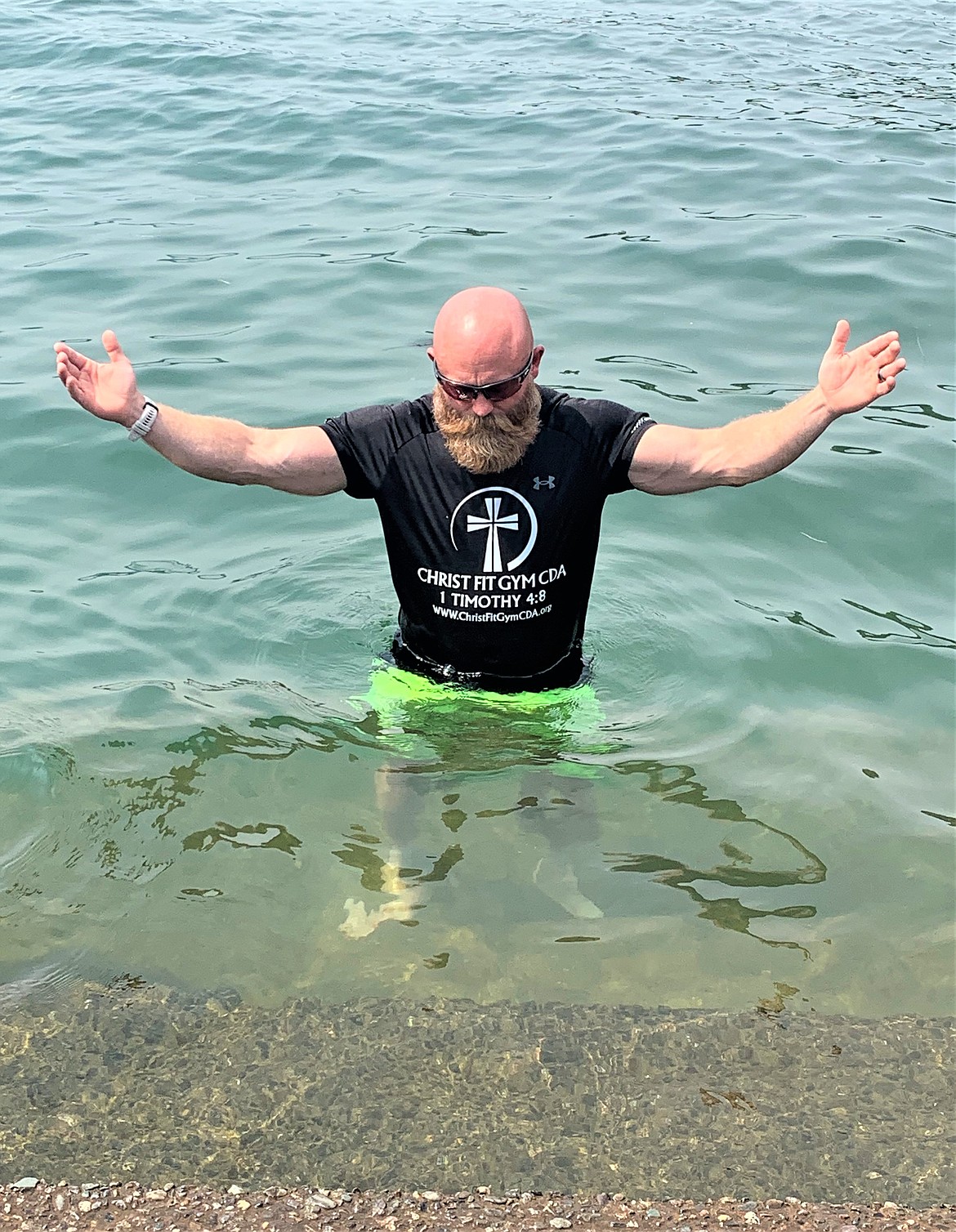 Robbie Walden raises his arms as he prays in Lake Coeur d'Alene at Independence Point during a break from a 33-mile cross walk on Saturday.