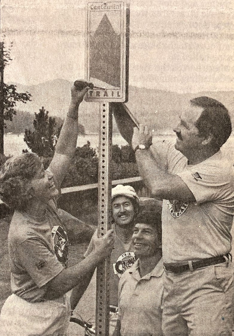 Commissioner Evalyn Adams and Councilman Bob Macdonald install the first Centennial Trail sign while Doug Eastwood and Randy Haddock watch.